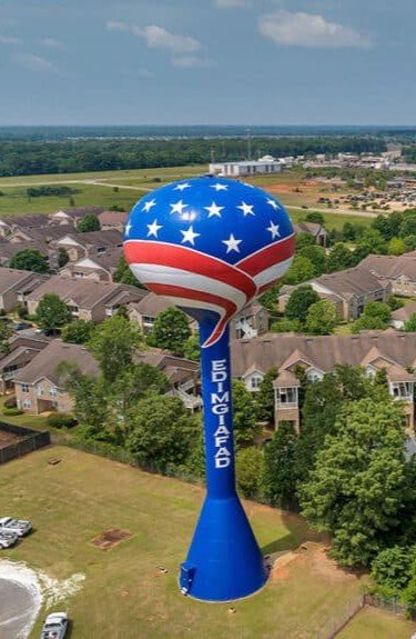Warner Robins, Georgia water tower landmark overlooking residential neighborhoods, representing the Middle Georgia communities Dinosaur Roofing & Repair proudly serves with reliable residential and light commercial roofing services